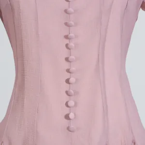 Primer plano detallado del corpiño de un vestido de verano rosa con botones forrados