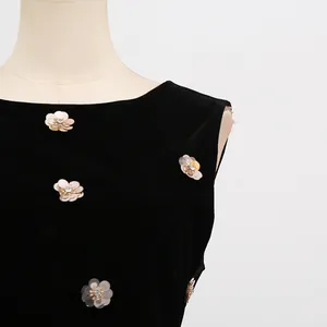 Close-up van elegante florale lovertjes en kralenversieringen op een zwarte mouwloze jurk
