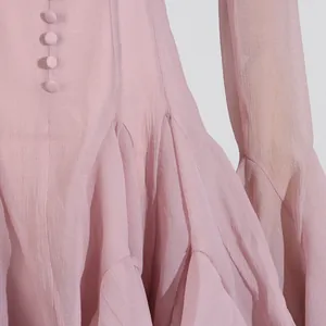 Detalle de un vestido rosa de verano con volantes de gasa texturizada y botones elegantes