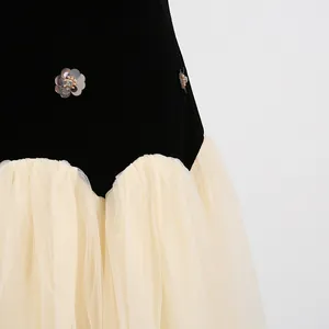 Detailopname van het zwarte fluwelen lijfje met lovertjesbloemen en crème tule rok.