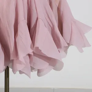 Detalle de primer plano del dobladillo de gasa rosa con volantes en un vestido de verano