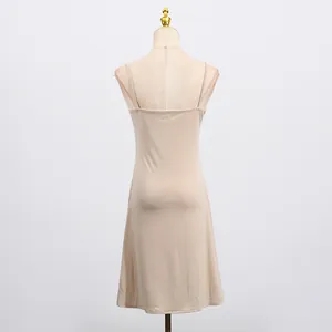 Detailed back view of a beige slim fit French style camisole slip dress on mannequin