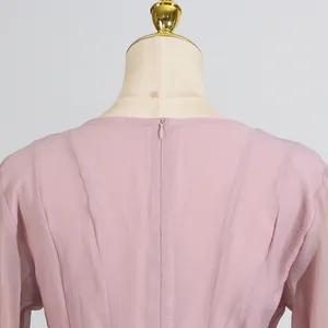 Vista detallada de la espalda de un vestido de gasa rosa con cremallera invisible