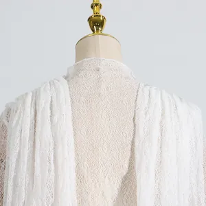 Nahaufnahme der komplizierten weißen Netze-Spitze und Rüschenlagen an einem Kleid