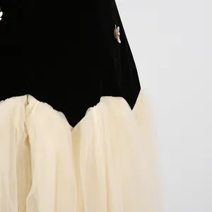 Detailopname van een elegante jurk met zwart fluweel en combinatie van beige tule