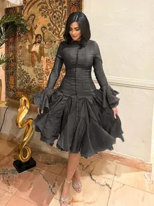 Elegant black long sleeve midi dress featuring a dramatic ruffled hem and front button detailing