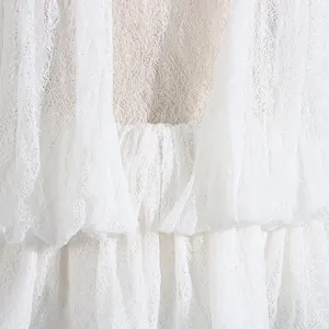 Nahaufnahme aufwendiger weißer Spitzenrüschen am Netzkleid-Detail