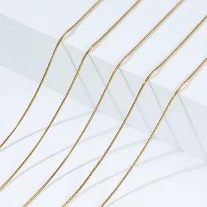 Close-up detail of a minimalist golden stainless steel snake chain necklace for women
