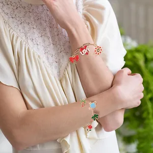 Detaillierte Ansicht goldener Büroklammer-Armbänder mit bunten Emaille-Anhängern