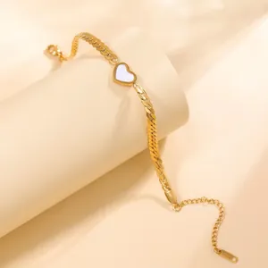 Détail d'un bracelet gourmette plaqué or 18 carats avec pendentif cœur en nacre blanche