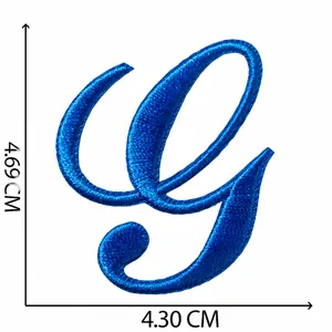 Vista dettagliata di una toppa ricamata blu lettera G con cuciture intricate e dimensioni
