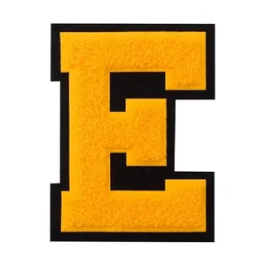 Close-up macro view of yellow chenille letter E embroidery patch for DIY clothing repair