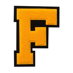 Detailed macro shot of yellow chenille embroidery letter F patch for DIY clothing