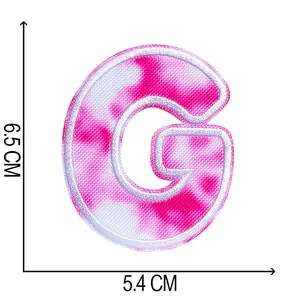Detail of a pink tie-dye embroidered letter G patch showing 6.5x5.4cm dimensions