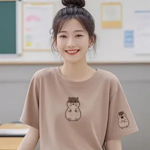 Detailed view of cute cartoon marmot embroidery patches applied on a brown T-shirt sleeve.