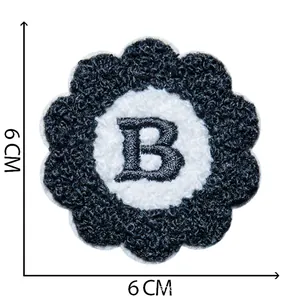 Detailed view of a flower-shaped chenille patch with an embroidered black letter B, 6cm size
