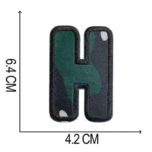 Dettaglio della toppa ricamata lettera H mimetica con dimensioni 6,4 cm per 4,2 cm