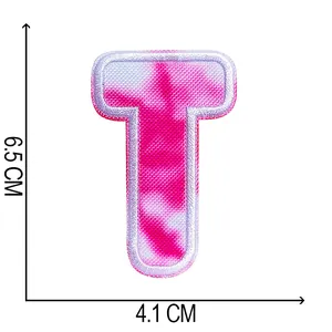 Close-up of pink tie-dye embroidered letter T patch with 6.5cm by 4.1cm size markings