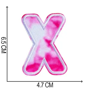 Detail showing tie-dye embroidered letter X patch with 6.5 x 4.7 cm dimensions