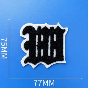 Détail de l'écusson brodé en bouclette noire, lettre W, dimensions 77mm x 75mm