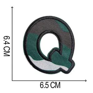 Primo piano di una toppa ricamata mimetica lettera Q con dimensioni di 6,5x6,4 cm