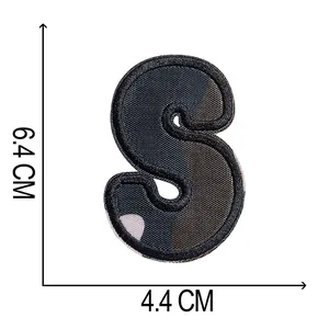 Dettaglio della toppa ricamata a forma di lettera S mimetica, dimensioni 6,4 x 4,4 cm
