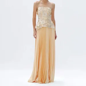 Close-up detail of champagne 3D floral strapless top paired with pleated maxi skirt
