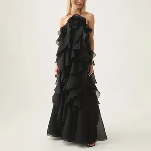 Detailed view of elegant black halter maxi dress with cascading ruffles and rose detail.