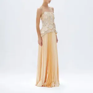 Elegant apricot two-piece set featuring a 3D floral strapless top and pleated maxi skirt.