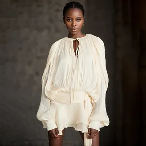 Elegant cream pleated mini dress featuring voluminous bubble sleeves and chic ruffle details