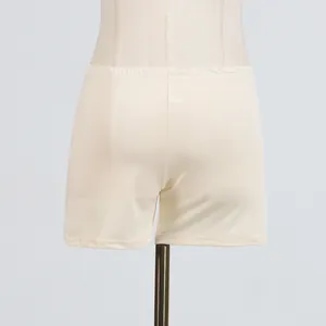 Detailed close-up of cream-colored high-waist elastic safety shorts on a mannequin stand.
