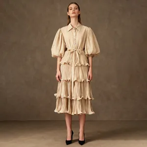 Detail of elegant beige tiered midi dress with crystal-embellished puff sleeves and collar.