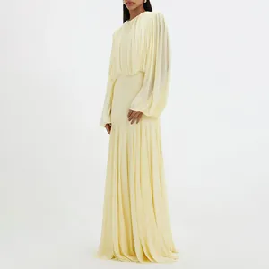 Elegant yellow pleated maxi dress with round neck and long billowy sleeves.