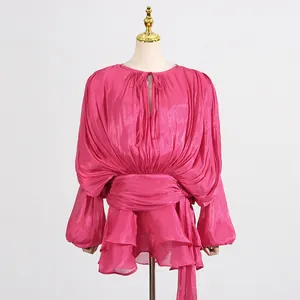 Close-up detail of hot pink pleated mesh puff sleeve mini dress with ruffled layered hemline