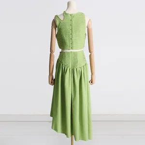 Vista trasera detallada de top corto plisado verde y falda midi a juego en maniquí