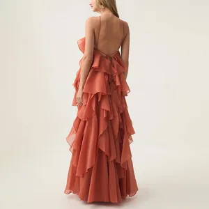 Detailed back view of an elegant coral ruffled maxi dress with a halter open back design
