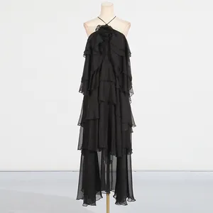 Close-up detail of a black halter neck ruffled maxi dress with elegant floral bust design