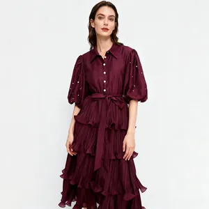 Elegant burgundy tiered dress with pearl details and puff sleeves in a French style.