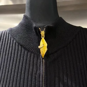 Dettaglio macro di un abito in maglia nera con cerniera dorata a forma di labbra