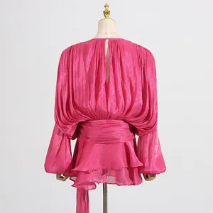 Back view of a pink pleated mesh mini dress with bubble sleeves and layered ruffles
