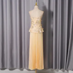 Back view of elegant party set with 3D floral strapless top and pleated maxi skirt