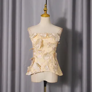 Elegant sleeveless strapless top with 3D floral appliques and a cinched waistline