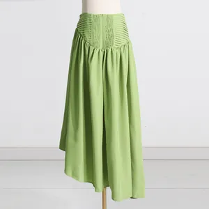Detalle de la cintura elástica y pliegues elegantes en falda larga verde claro.