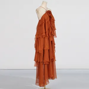 Detailed side view of an elegant orange tiered ruffle halter maxi dress on a mannequin