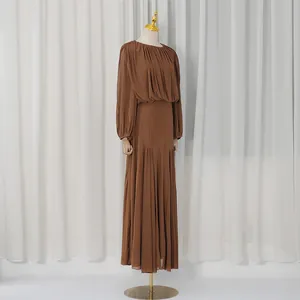 Side view of elegant brown pleated maxi dress on mannequin against white curtains