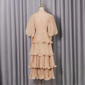 Back view of an apricot French style pleated tiered dress with puff sleeves and rhinestones.