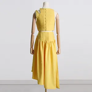 Vista trasera de conjunto amarillo de dos piezas con top plisado y falda asimétrica