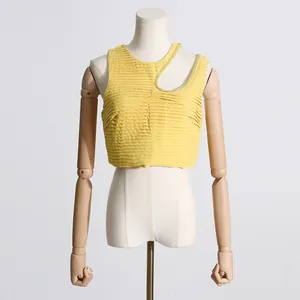 Primer plano detallado de un top corto amarillo plisado sin mangas con cuello recortado de cuentas
