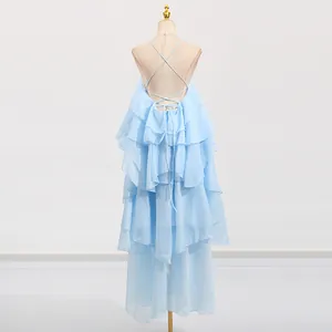 Detailed view of the layered ruffles and backless criss-cross straps on a light blue dress