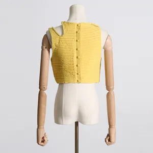 Vista trasera de un crop top amarillo plisado con cierre de botones y tira de perlas